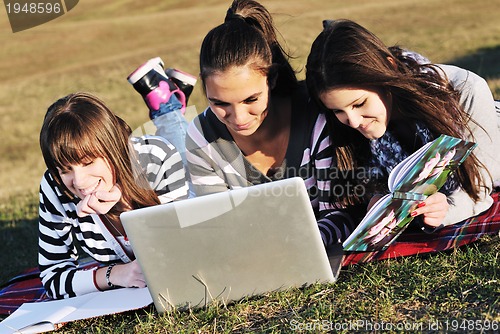 Image of group of teens working on laptop outdoor