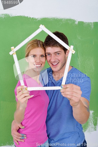 Image of happy couple paint wall at new home