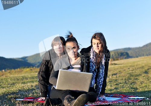 Image of group of teens working on laptop outdoor