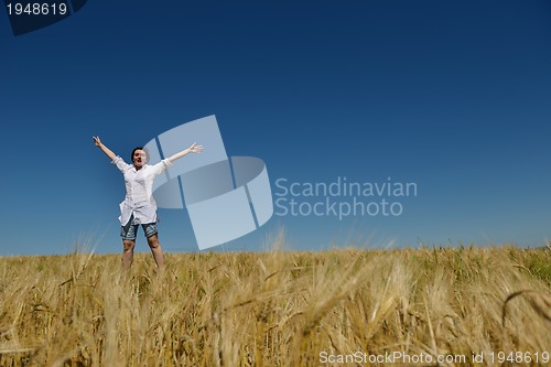 Image of young woman in wheat field at summer