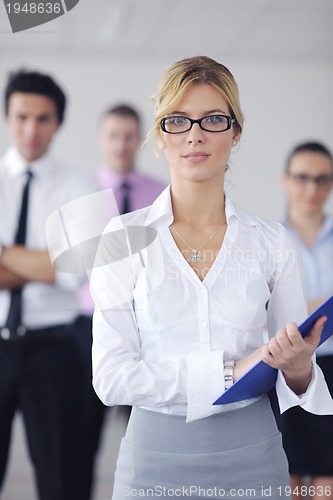 Image of business woman standing with her staff in background
