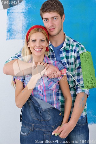 Image of happy couple paint wall at new home