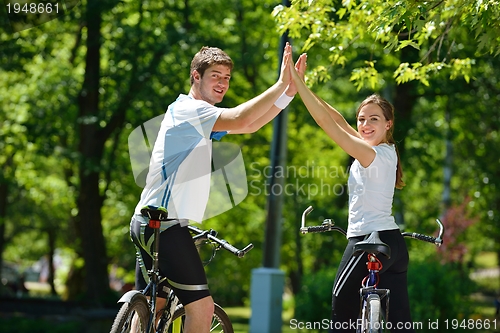 Image of Happy couple ridine bicycle outdoors