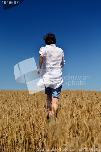 Image of young woman in wheat field at summer