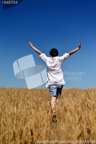 Image of young woman in wheat field at summer