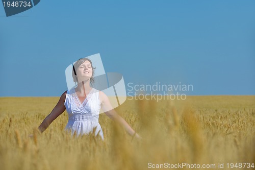 Image of young woman in wheat field at summer