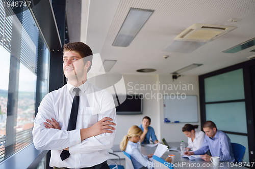 Image of business man  on a meeting in offce with colleagues in backgroun