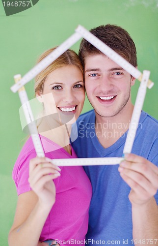 Image of happy couple paint wall at new home