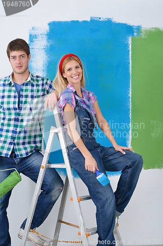 Image of happy couple paint wall at new home