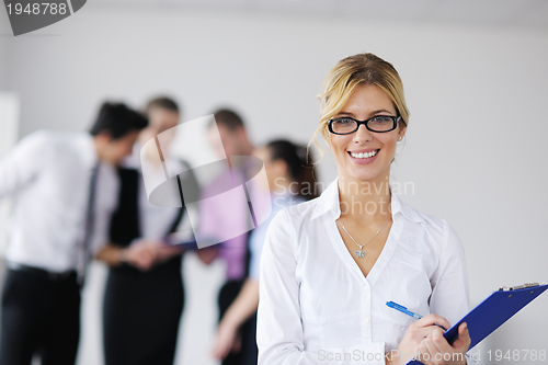 Image of business woman standing with her staff in background