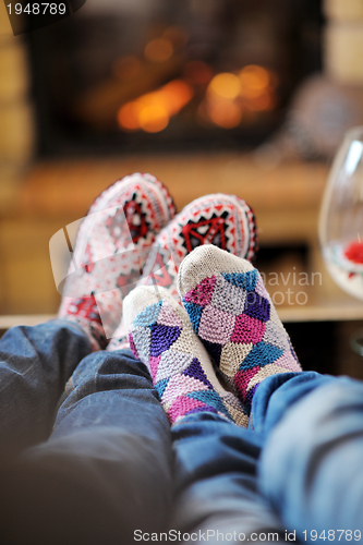 Image of Young romantic couple relax on sofa in front of fireplace at hom