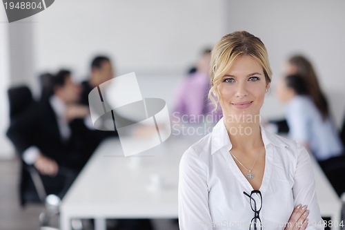 Image of business woman standing with her staff in background