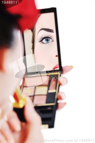 Image of beautiful young woman applying makeup
