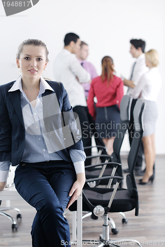 Image of business woman standing with her staff in background