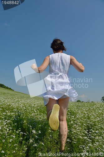 Image of Young happy woman in green field