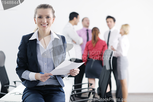 Image of business woman standing with her staff in background