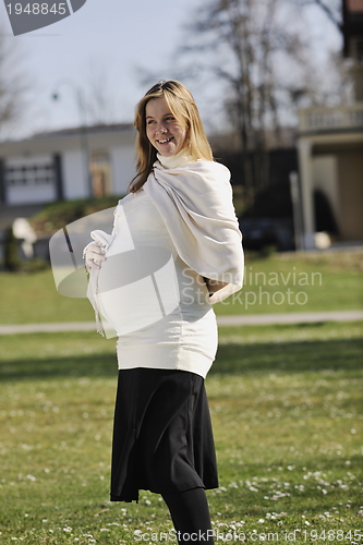 Image of happy young pregnant woman outdoor