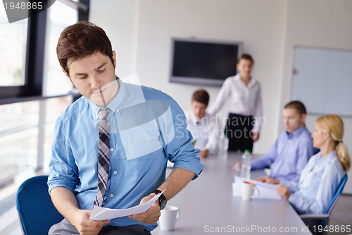 Image of business man  on a meeting in offce with colleagues in backgroun