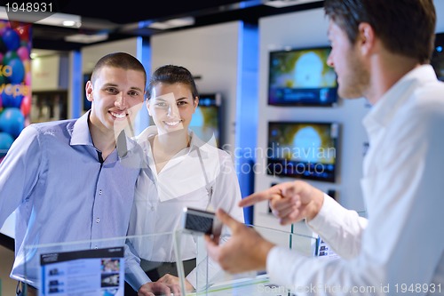 Image of Young couple in consumer electronics store