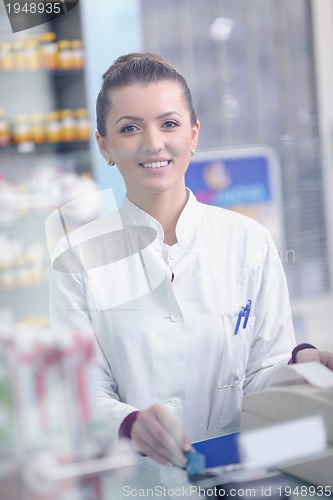Image of pharmacist chemist woman standing in pharmacy drugstore
