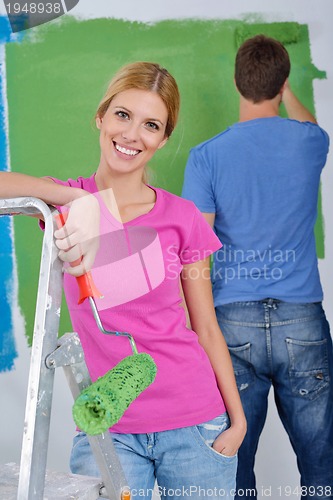 Image of happy couple paint wall at new home