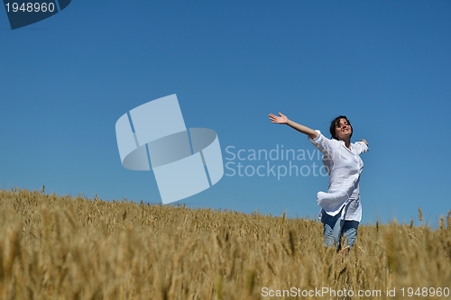 Image of young woman in wheat field at summer