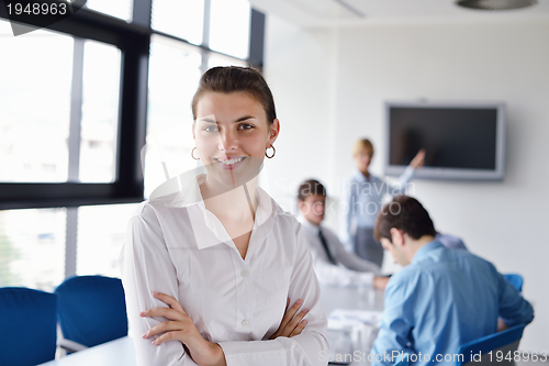 Image of business woman with her staff in background at office