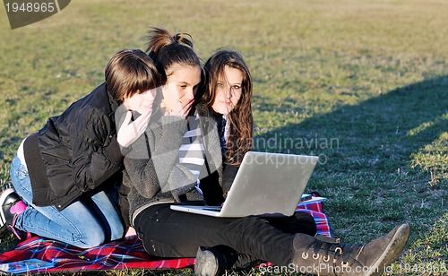 Image of group of teens working on laptop outdoor
