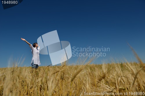 Image of young woman in wheat field at summer