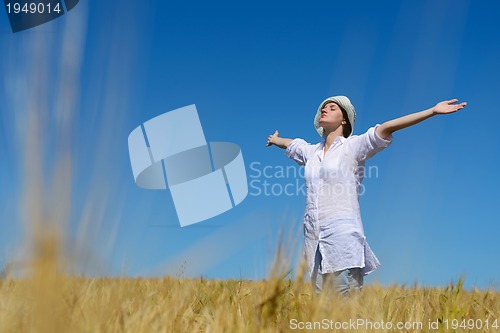 Image of young woman in wheat field at summer
