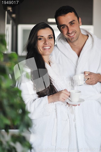 Image of Young love couple taking fresh morning cup of coffee