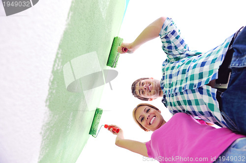 Image of happy couple paint wall at new home