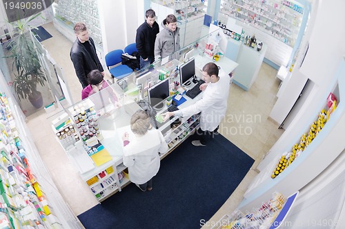 Image of pharmacist suggesting medical drug to buyer in pharmacy drugstor