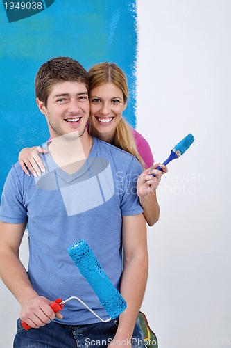 Image of happy couple paint wall at new home