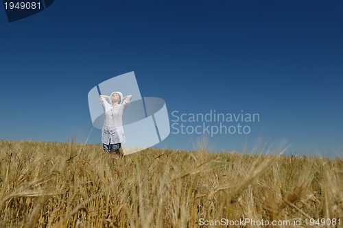 Image of young woman in wheat field at summer