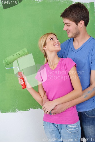 Image of happy couple paint wall at new home