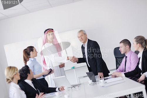 Image of business woman standing with her staff in background