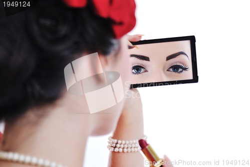 Image of beautiful young woman applying makeup