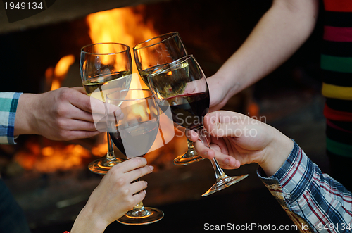 Image of Young romantic couple sitting on sofa in front of fireplace at h