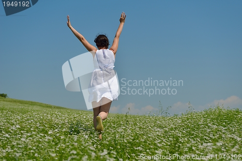 Image of Young happy woman in green field
