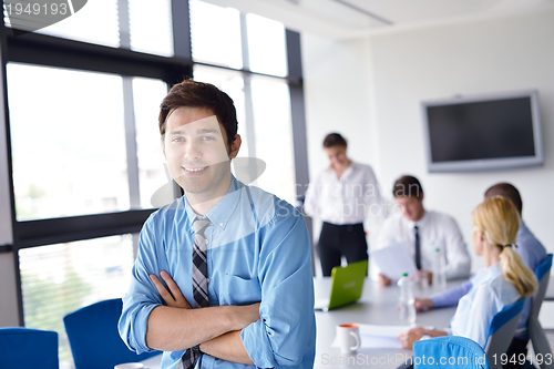 Image of business man  on a meeting in offce with colleagues in backgroun