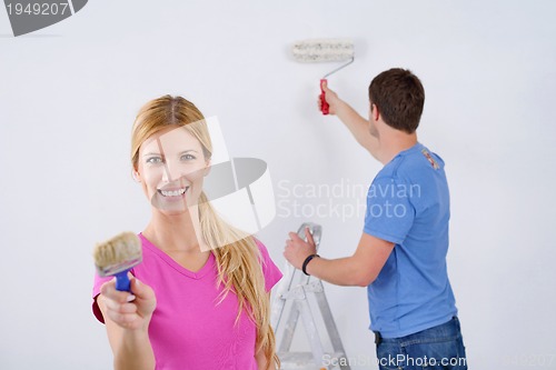 Image of happy couple paint wall at new home