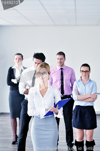 Image of business woman standing with her staff in background