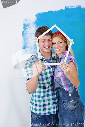 Image of happy couple paint wall at new home