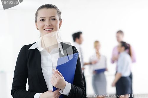 Image of business woman standing with her staff in background