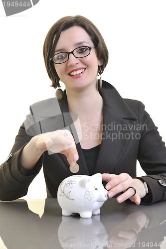 Image of business woman putting money coins in piggy bank