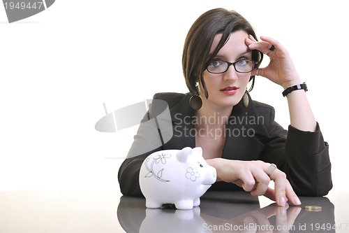 Image of business woman putting money coins in piggy bank