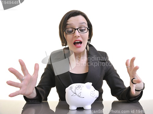 Image of business woman putting money coins in piggy bank