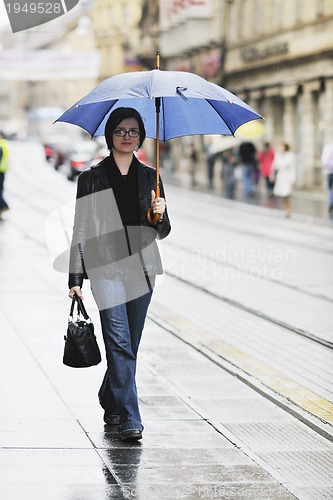 Image of woman on street with umbrella