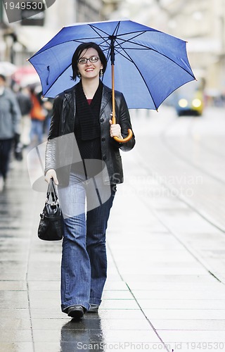 Image of woman on street with umbrella